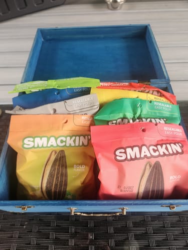 Customer's colorful bags of SMACKIN' sunflower seeds from the VARIETY PACK inside an open box.