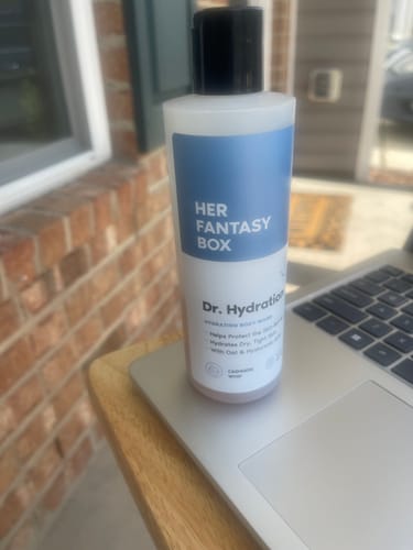 Customer's bottle of Dr. Hydration Moisturizing Body Wash sitting on a laptop outdoors.