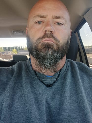 Reviewer wearing the Legacy Necklace, showing its small size over a grey sweatshirt.