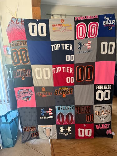 Customer's large Project Repat T-Shirt Quilt made from a colorful patchwork of their son's sports jerseys.
