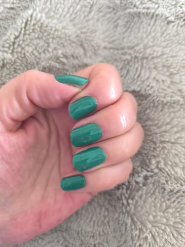 Kundenfoto einer Hand, die die UV-Gel-Nagelfolien „Shamrock Isle“ in einem satten, glänzenden Grünton auf kurzen Nägeln zeigt.