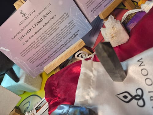 Customer displays their monthly VIP Crystal Club items, including a dark Hematite Crystal Point and info card.
