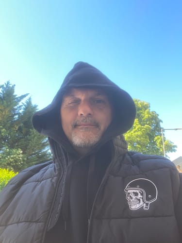 Client portant un sweat à capuche noir avec la capuche relevée à l'extérieur par temps ensoleillé.
