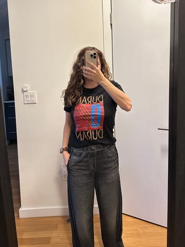 Reviewer taking a mirror selfie to show the fit of the black Ladies Duran Duran Shirt.