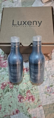 Cliente muestra el Shampoo y Acondicionador Post-Alisado de Luxeny, nuevos y sellados, frente a su caja.