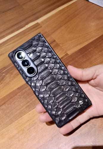 Un cliente sostiene su teléfono, que luce la funda ZFOLD7 negra de piel de pitón.