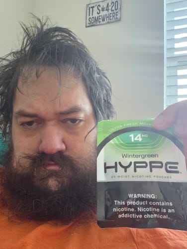 Reviewer holding up a sealed bag of Wintergreen 14mg HYPPE Moist Pouches.