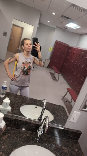 Reviewer wearing the Depth Vader Stonewash Tank Top in a gym locker room.