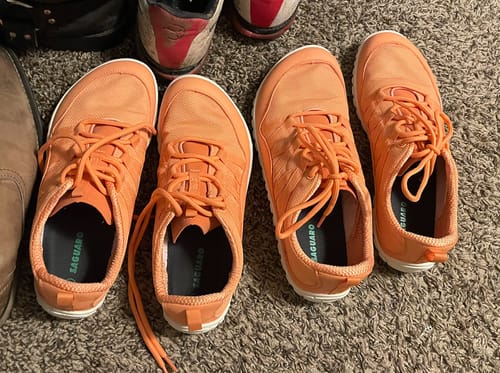 Customer's two pairs of orange Forestep Ⅰ - Barefoot Shoes shown side-by-side on a carpeted floor.