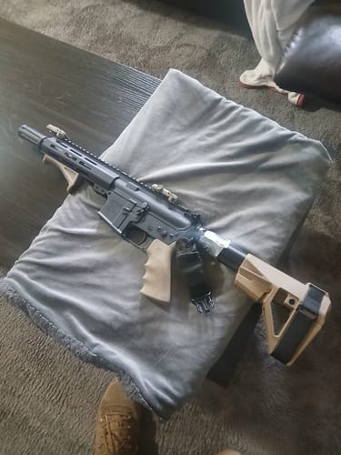 Customer's black and tan AR-15 pistol, built with the Hoffman Tactical Super Safety, resting on a grey pillow.