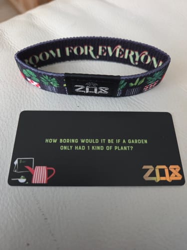 Customer's Room For Everyone Bracelet with plant designs, displayed next to its black themed card on a white surface.
