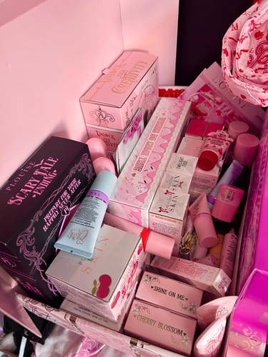 Customer's Unlock Your Creativity palette box among a collection of other beauty products in pink packaging.