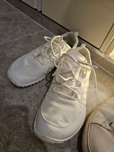 Customer's white Forestep Ⅰ Barefoot Shoes sitting on a gray tiled floor.