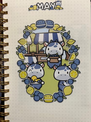Customer's journal page with a cute sticker collage from the Ultimate Subscription, showing blue cows and lemons.