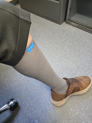 Customer wearing the grey Performance Eucalyptus Compression Socks with cuffed pants and shoes.