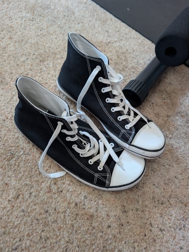 Customer's pair of black and white Roam I - Barefoot Shoes sitting on a carpet.