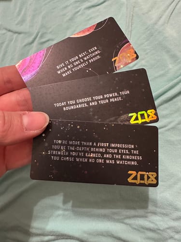 Customer holding three black collector's cards with quotes from their Legacy Mystery Club+ subscription.