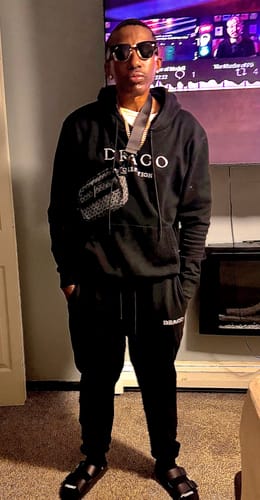 Reviewer wearing the stylish Draco Messenger Bag crossbody with a matching black Draco outfit.