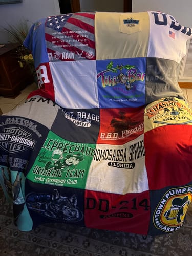 Customer's completed T-Shirt Quilt made from memorial t-shirts, shown draped over a living room chair.