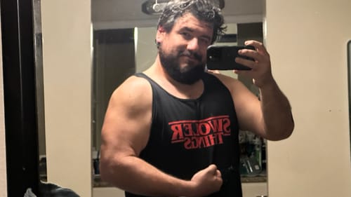 Reviewer in a black Swoler Things Tank Top flexing for a mirror selfie, showing the fit.