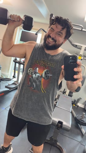 Reviewer in a gym wearing the Depth Vader Stonewash Tank Top while lifting a dumbbell.
