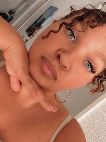 Nahaufnahme einer Kundin, die ihre Pretty Press Pre-Glued Wimpern mit einem weichen Cateye-Effekt trägt.