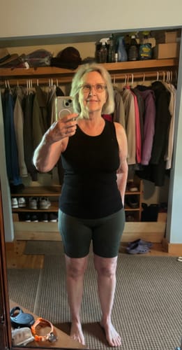 Reviewer wearing the black Ava Tank Top, showing its high neckline and fit in a mirror selfie.
