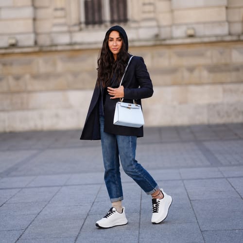 Reviewer wearing white CloudStep™ Comfort Sneakers with cuffed jeans and a black blazer.