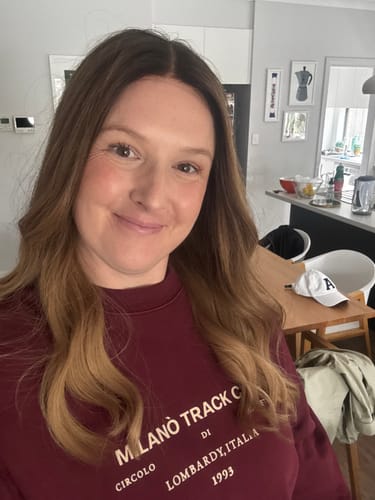 Reviewer smiling while wearing the Burnt Blonde Lusta Lace Wig, showing its darker roots and golden lengths.