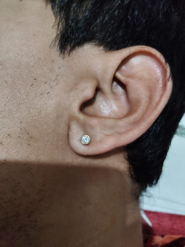 Close-up of a reviewer's ear, showing the Gold Circolare Diamond Nose Pin being worn as a small stud earring.