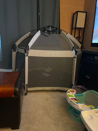 Customer's grey and white Pop 'N Go LUXE Playpen fully set up in their living room.