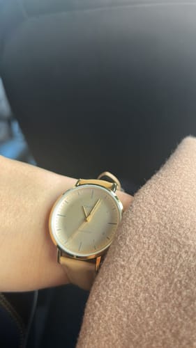 Cliente mostrando su reloj Casio análogo LTP-VT03GL-4B beige en la muñeca.