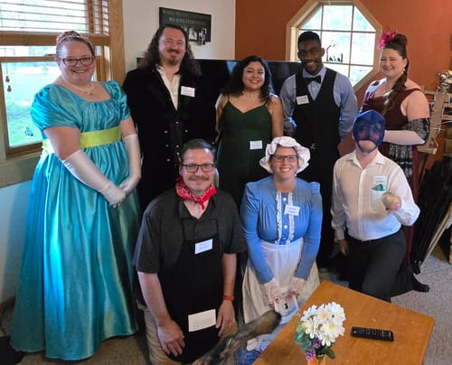 Reviewer and friends in fun, historical costumes playing the Bridgerton Murder Mystery Game.