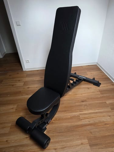 Rezensent-Foto der komplett montierten, schwarzen B2 Situp Hantelbank auf einem Holzboden.