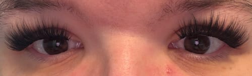 Eine Kundin mit einer Nahaufnahme ihrer langen, dramatischen ICON Wimpern.