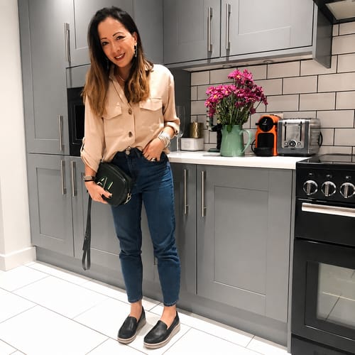 Reviewer wears black Soleva loafers with jeans and a beige shirt.