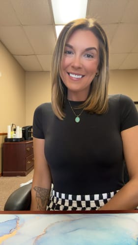 Customer smiling while wearing a beautiful necklace with a round turquoise pendant from the AuraBloom Subscription Box.