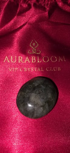 Customer's dark polished crystal resting on the red satin bag from the VIP Crystal Club.