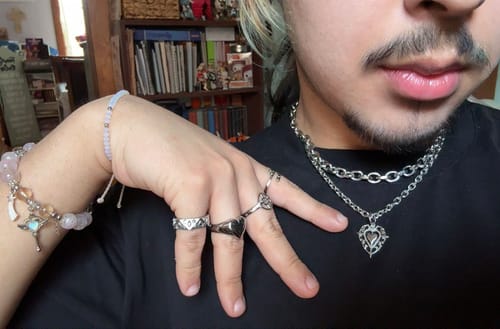 Customer wearing the ANTIQUE HEART PENDANT on a layered necklace against a black top.