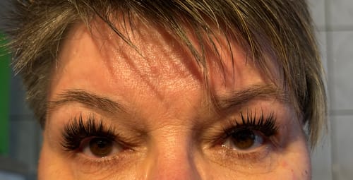 Nahaufnahme der Augen einer Kundin, die die langen, dramatischen ICON Wimpernverlängerungen trägt.