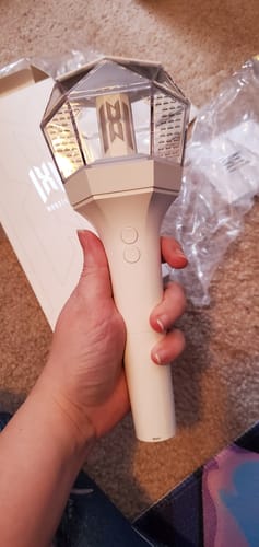 Reviewer holding the white MONSTA X OFFICIAL LIGHT STICK VER.3, with the top section lit.