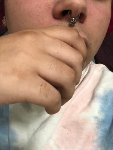 Close-up of a reviewer wearing the silver Spiked Heart Septum in their nose.