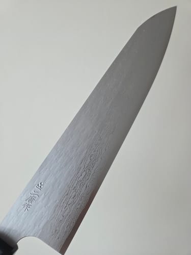Close-up of the customer's Nigara Hamono Gyuto, showing the blade's textured Damascus finish near the handle.