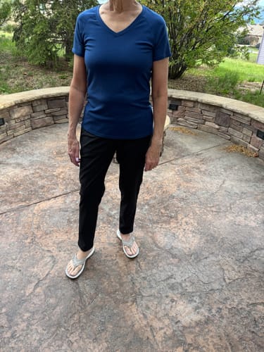Customer stands outdoors wearing the black Nicole Ankle Pants, showing their fit and length.