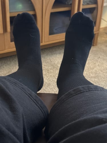 Reviewer relaxing while wearing the black Eucalyptus Lyocell Compression Socks.