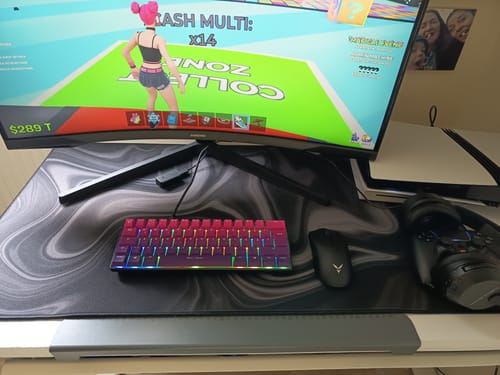 Ein Kunde zeigt sein RZ Mousepad Liquid Black auf einem Schreibtisch mit einem Gaming-Setup.