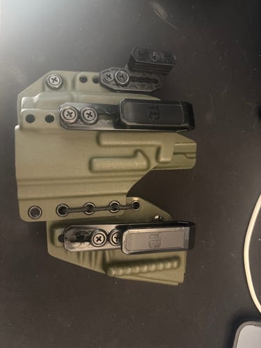 Customer's olive green AXIS ELITE holster with a concealment claw and spare magazine pouch laid flat.