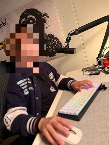 Kunde an einem Schreibtisch mit der leuchtenden, weißen RZ Gaming-Tastatur.
