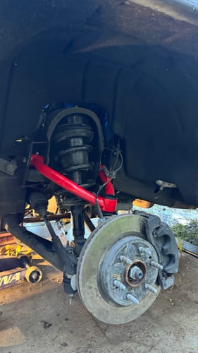 Close-up of the customer's red tubular control arm from the 3" lift kit installed on the front suspension.