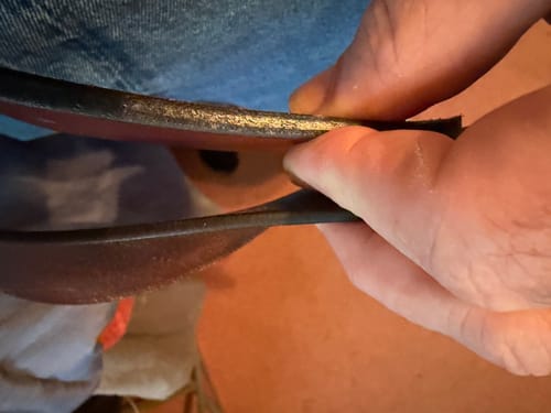 Close-up of a customer comparing the thickness of the Gunner belt to a much thinner belt.